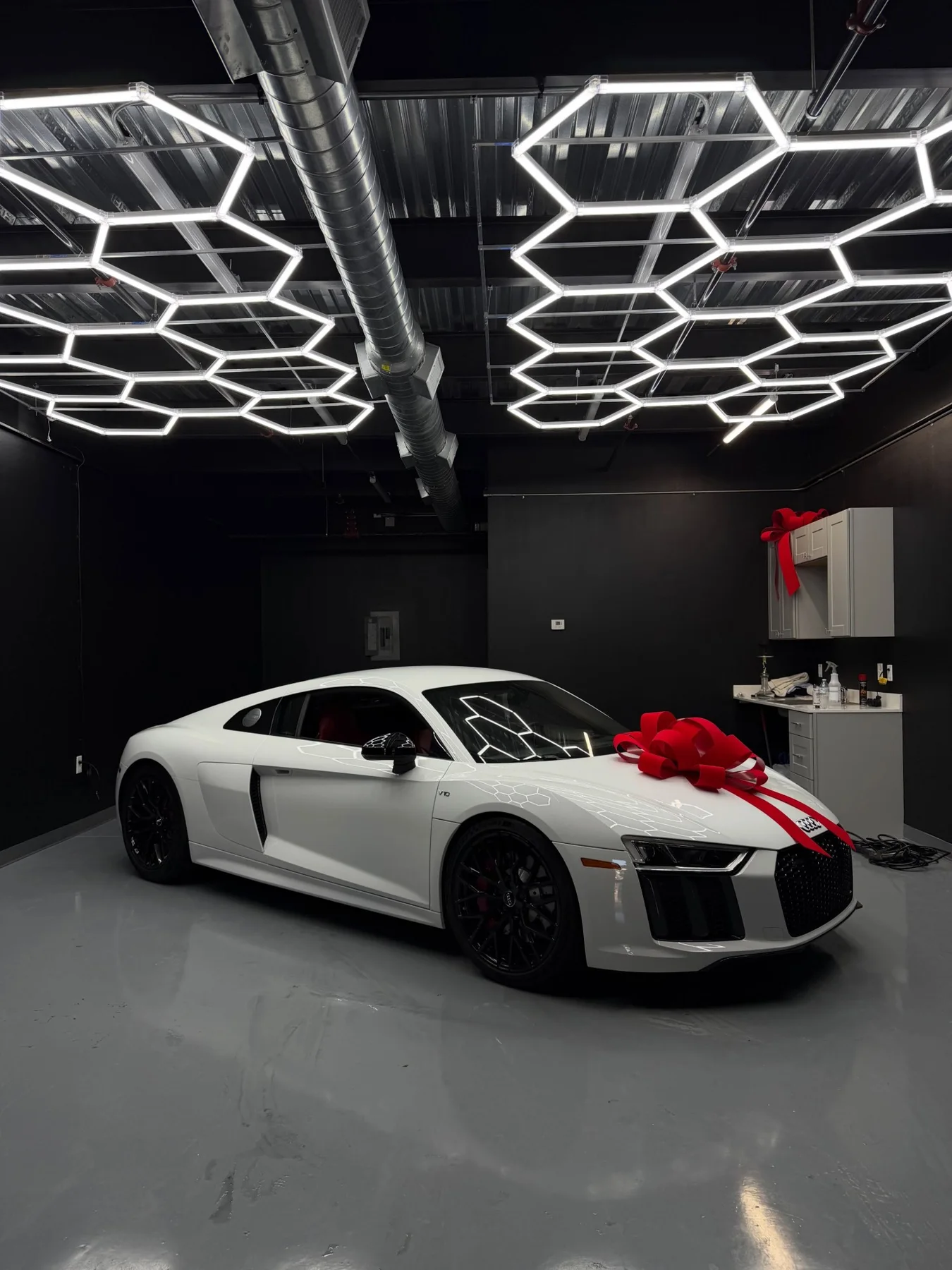 White Audi R8 with a red bow in the bay