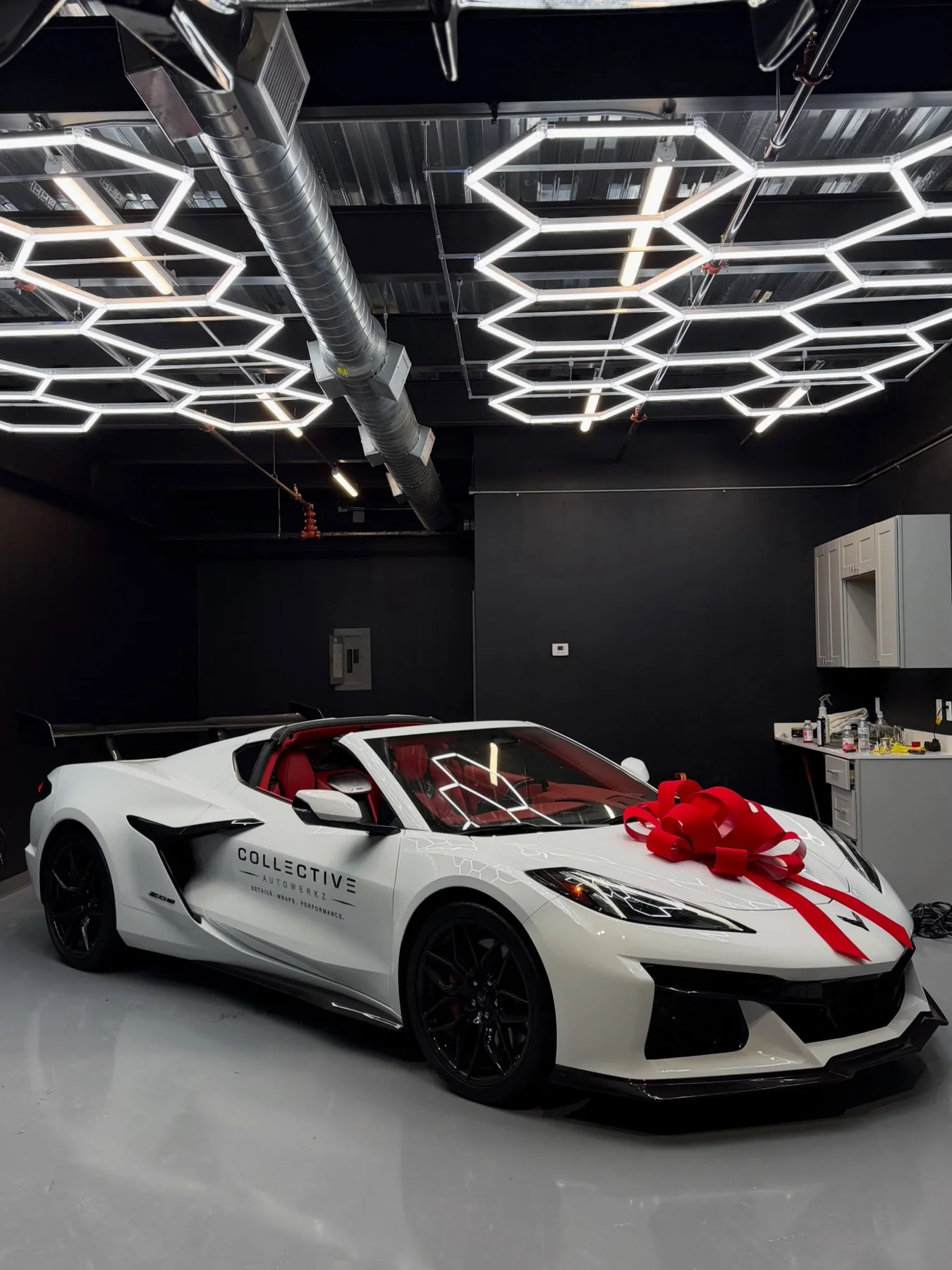 White Corvette Z06 with a red bow in the bay